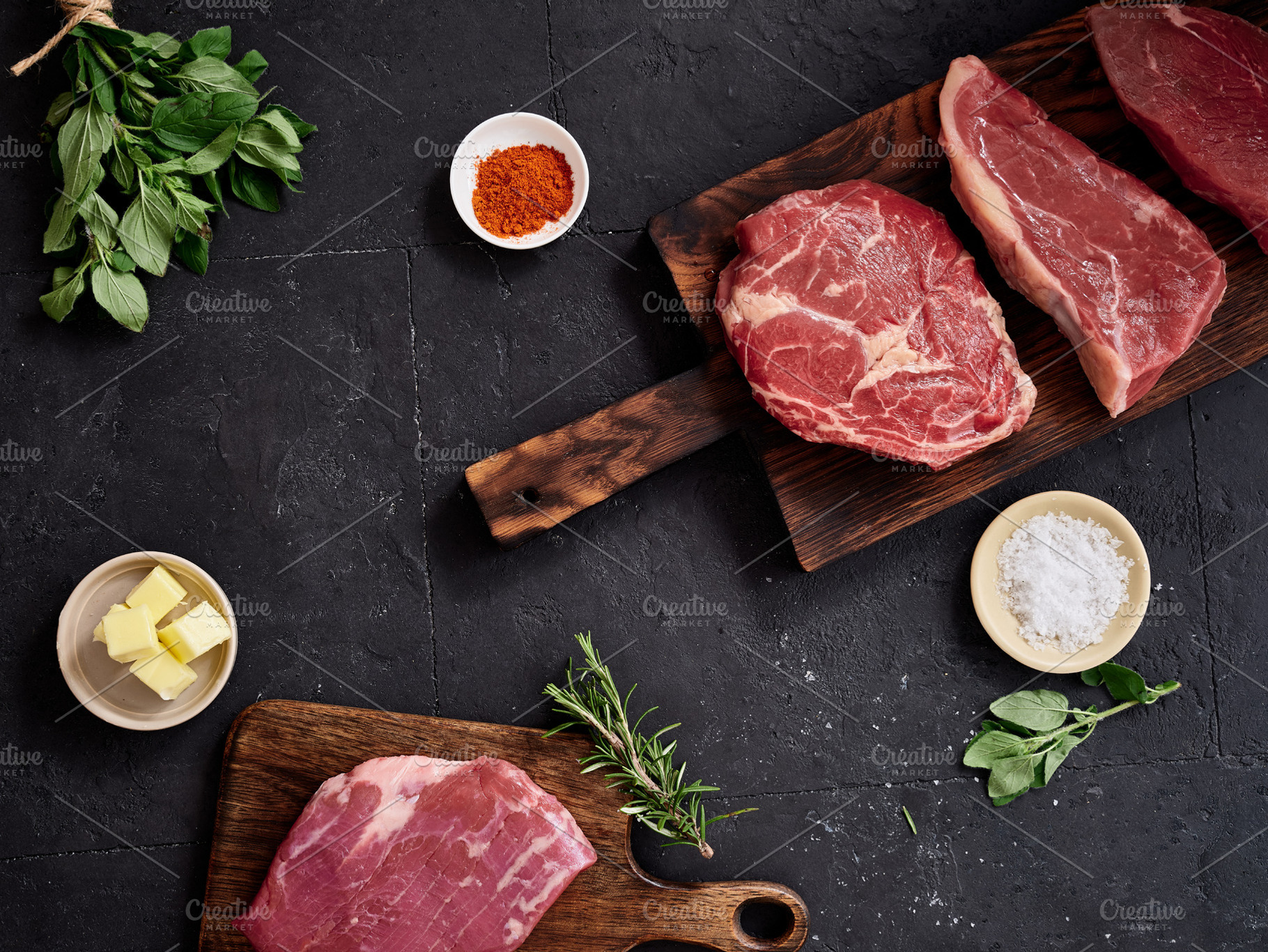 Raw rib-eye, flank, roast beef, and rump steak on wooden boards with spices and, a Food & Drink Photo by Asya Nurullina