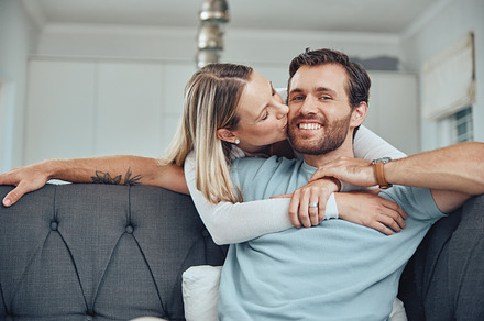 Love, couple and sofa kiss portrait in home for care, gratitude and intimate moment in home. Happy people in marriage bonding together in living room with romantic embrace with hug and smile., a Photo by Peopleimages.com