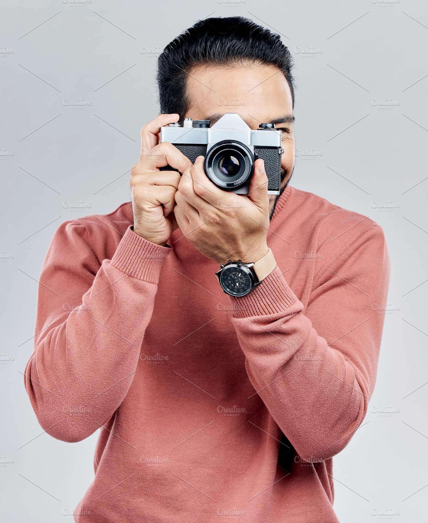Man with camera, photography and artist, taking picture with art isolated on gray background. Photographer, focus with lens and creativity with vintage technology and creative male in studio, a Photo by Peopleimages.com