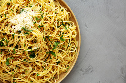 Homemade Italian Spaghetti Aglio e Olio on a Plate, top view. Fl, a Food & Drink Photo by LiudmylaChuhunova