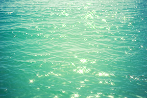 Sea background - turquoise water with glare of light