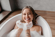 Playful lady having fun while lying in bathtub full of foam, blowing soap bubbl, a Photo by Prostock-Studio (Thumbnail 3 of 4)