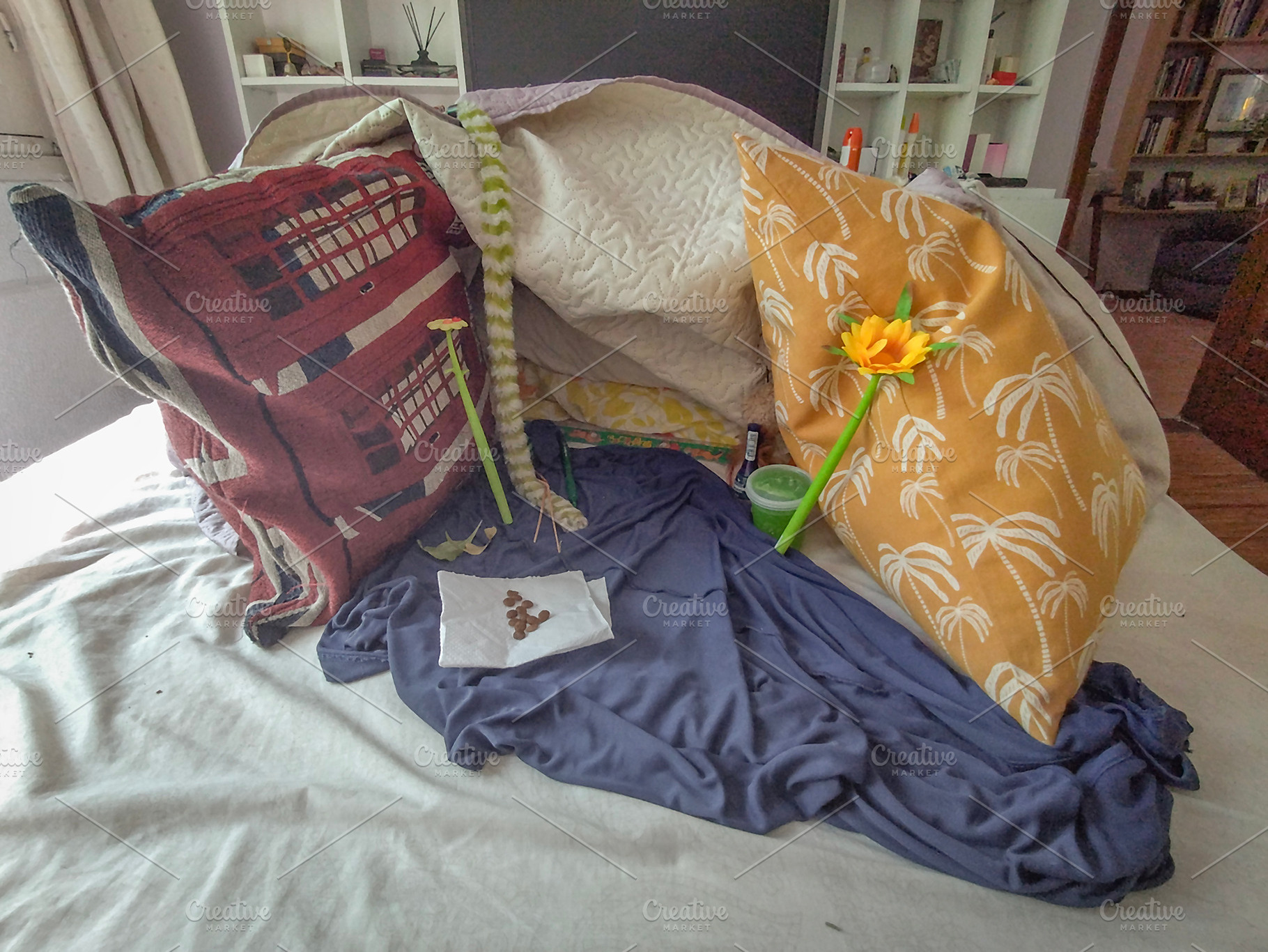 Messy bed with pillows and yellow flower, a Background Photo by DanFLCreativo
