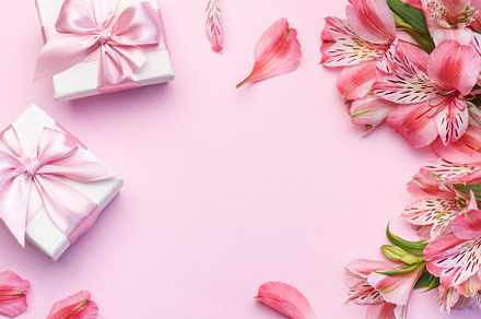 Beautiful Alstroemeria flowers and gift boxes on pink background, a Holiday Photo by Olena Rudo