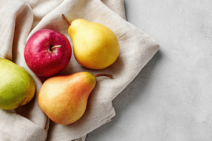 Seasonal selection of fresh apples and pears arranged on a soft cloth, a Food & Drink Photo by AlyaAnd