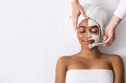 Beautician applying white mask on ha, a Photo by Prostock-Studio