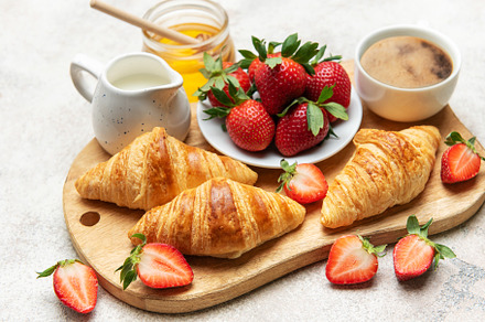 Delicious french breakfast with croissants, coffee, strawberries