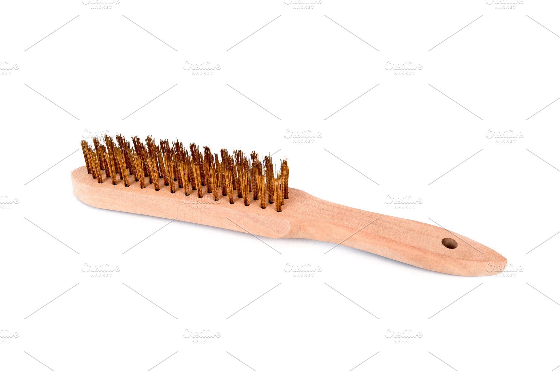 a wooden wire brush with brass bristles, a Photo by Nito