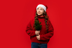 Teen girl in Santa hat holding small, a Holiday Photo by Elena Vagengeim
