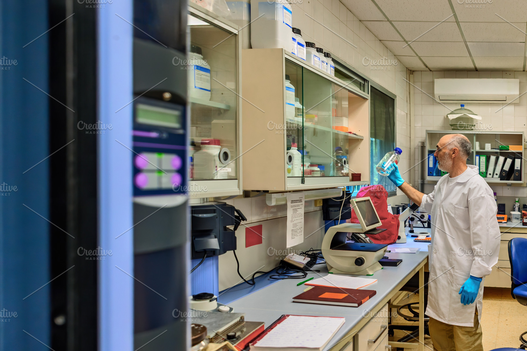 Scientist inspecting flask in a mode, a Health & Medical Photo by Perpis