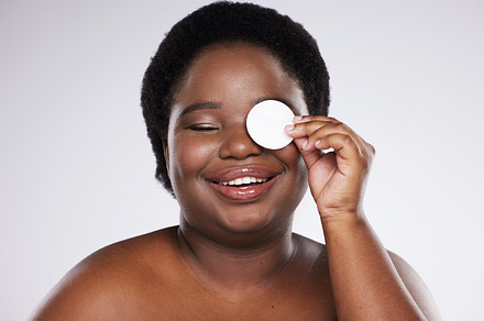Beauty, skincare and plus size with a model black woman in studio on a gray background for exfoliation. Face, skin and cotton swab with an attractive young female posing to promote natural health, a Photo by Peopleimages.com