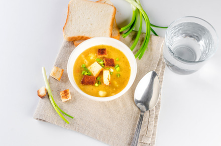 Split pea soup with croutons and green onion in a bowl on white, a Food & Drink Photo by vimart