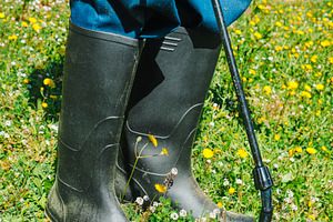 a man applies herbicide at ground level, a Photo by Nito