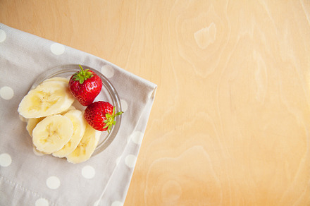 strawberry and banana on a glass plate on a wooden background., a Food & Drink Photo by Artsaba Family