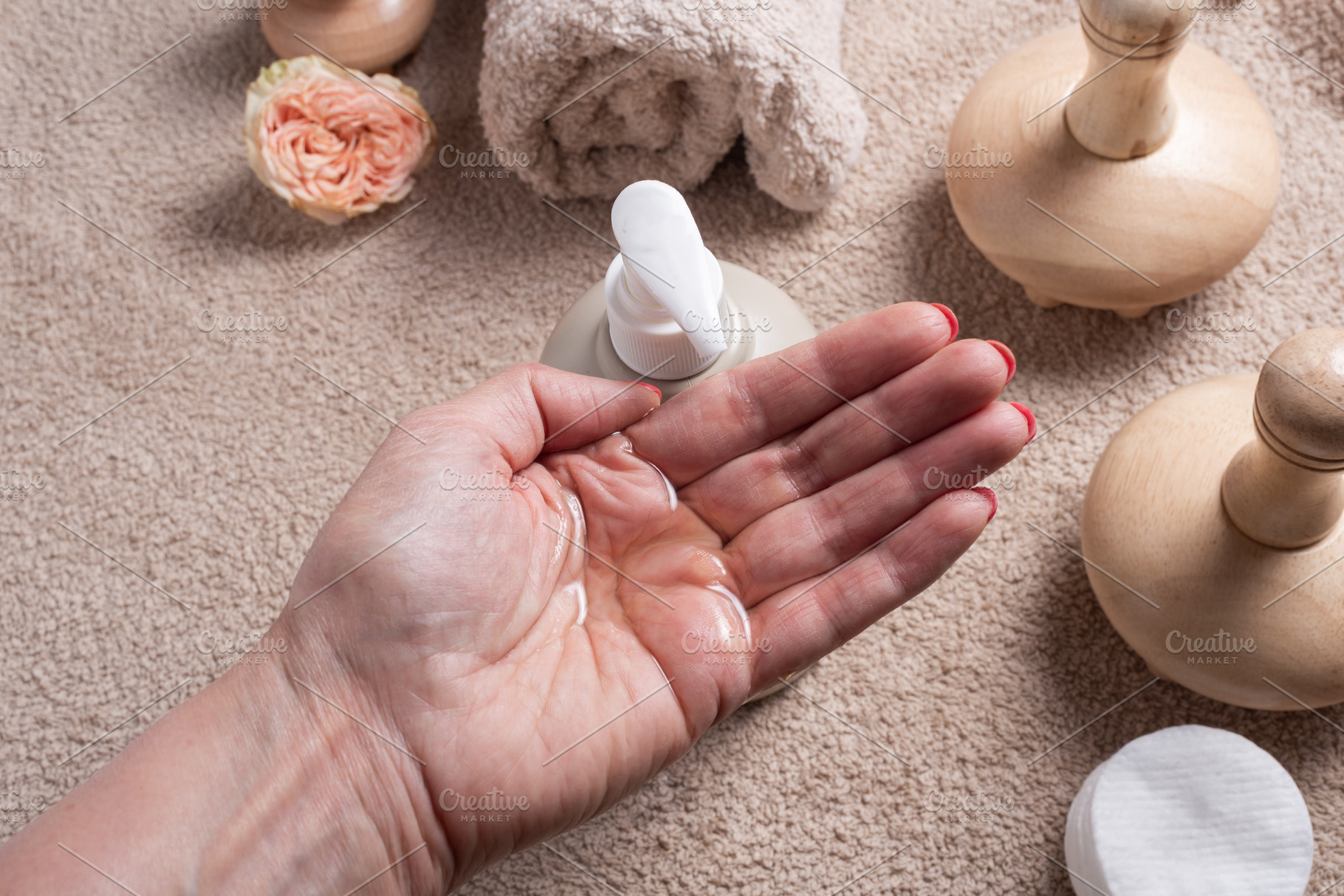 Female Hand Holding Massage Oil with Dispenser Bottle, Towel and, an Industrial Photo by MDBildes
