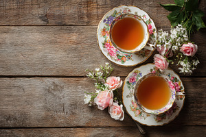Tea served in floral cups with pink, a Photo by Pavel_design