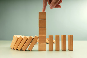 Falling row wooden blocks stopped by finger pushing one block up, a Photo by salmon.black