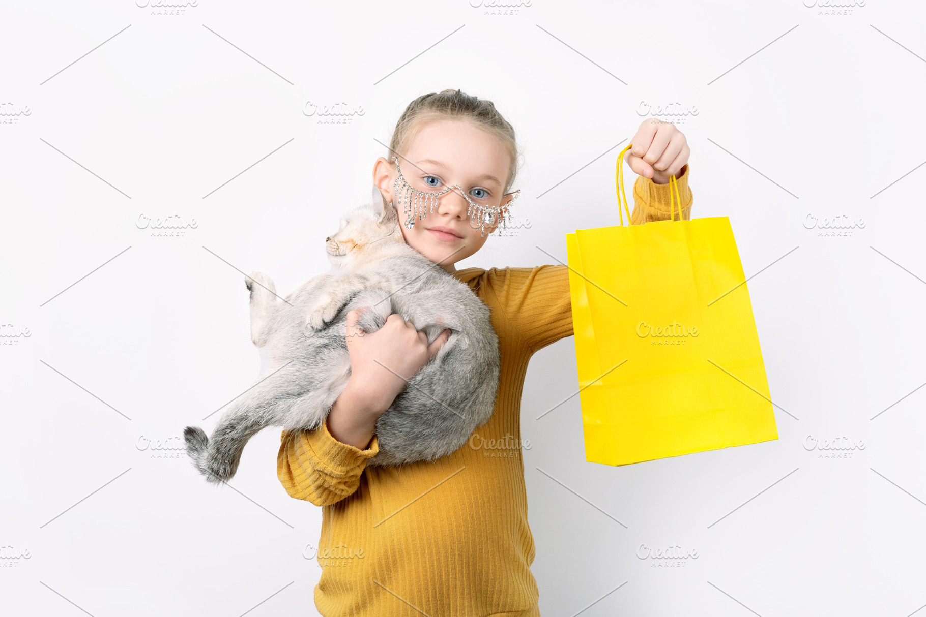 Young girl wearing glasses holds a gray cat and a bright yellow, a Person Photo by Ales Munt