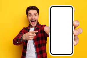 Shocked guy pointing at white empty smart phone screen