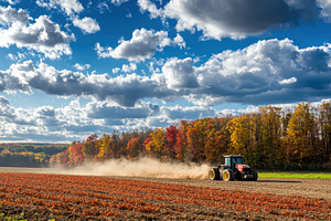 Tractor plows a dusty field, a Photo by Pavel_design