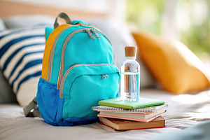 Colorful backpack and school supplies on a bed, an Arts & Entertainment Photo by AlyaAnd
