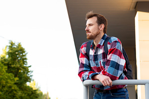 Young man leaning on railing looking, a Person Photo by Elena Vagengeim