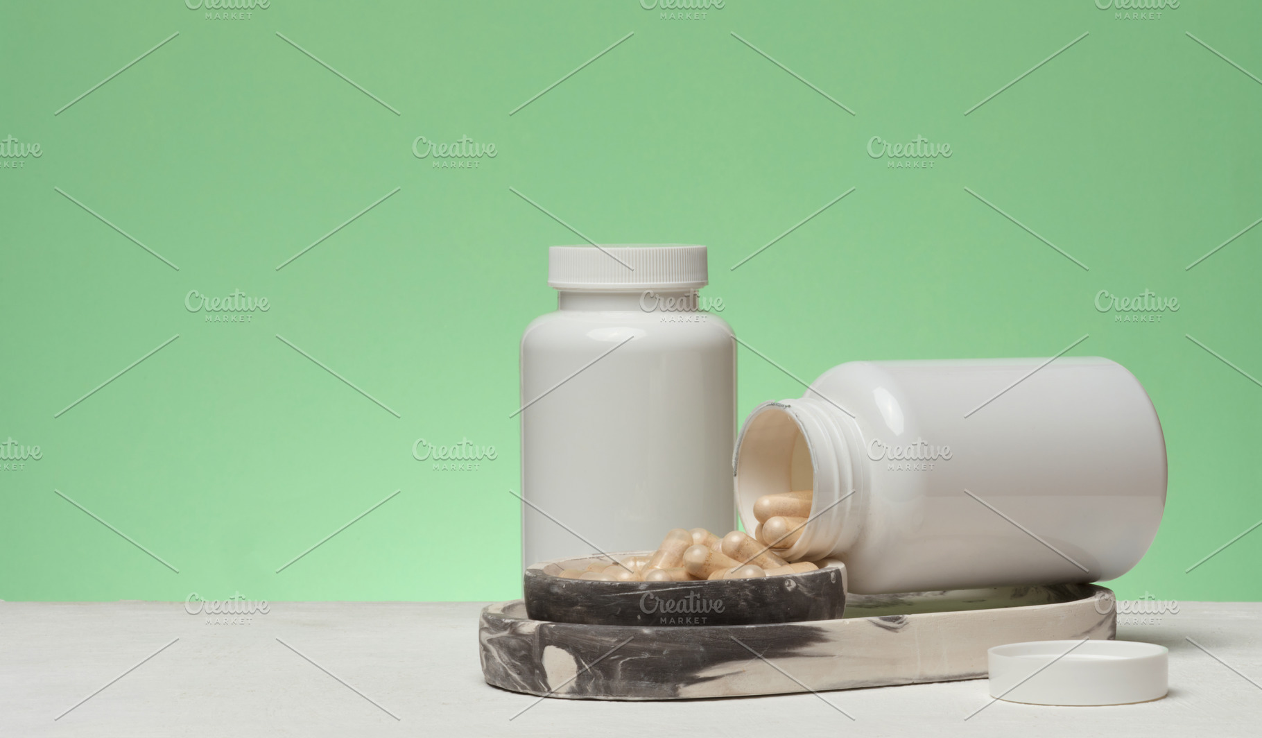 Two white plastic jars, one of which is overturned and capsules, a Health & Medical Photo by ndanko