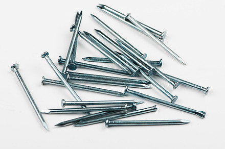 Stacked nails on white background. Isolated. Horizontal studio shot., an Industrial Photo by José Luis Agudo