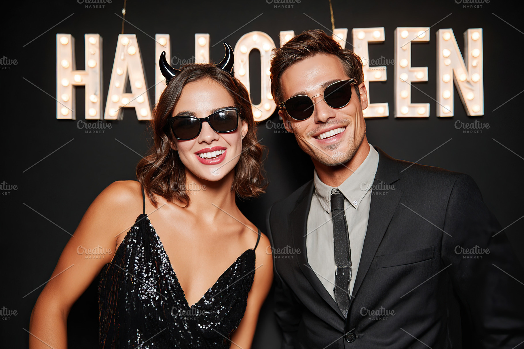 Stylish couple celebrating Halloween in fun costumes at a festive event, a Photo by AlyaAnd
