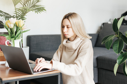 Young woman working on laptop in  home, a Person Photo by Olena Rudo