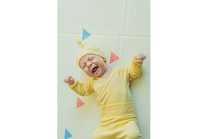 Adorable baby in a yellow hat lying, a Person Photo by Elizaveta Galitskaya