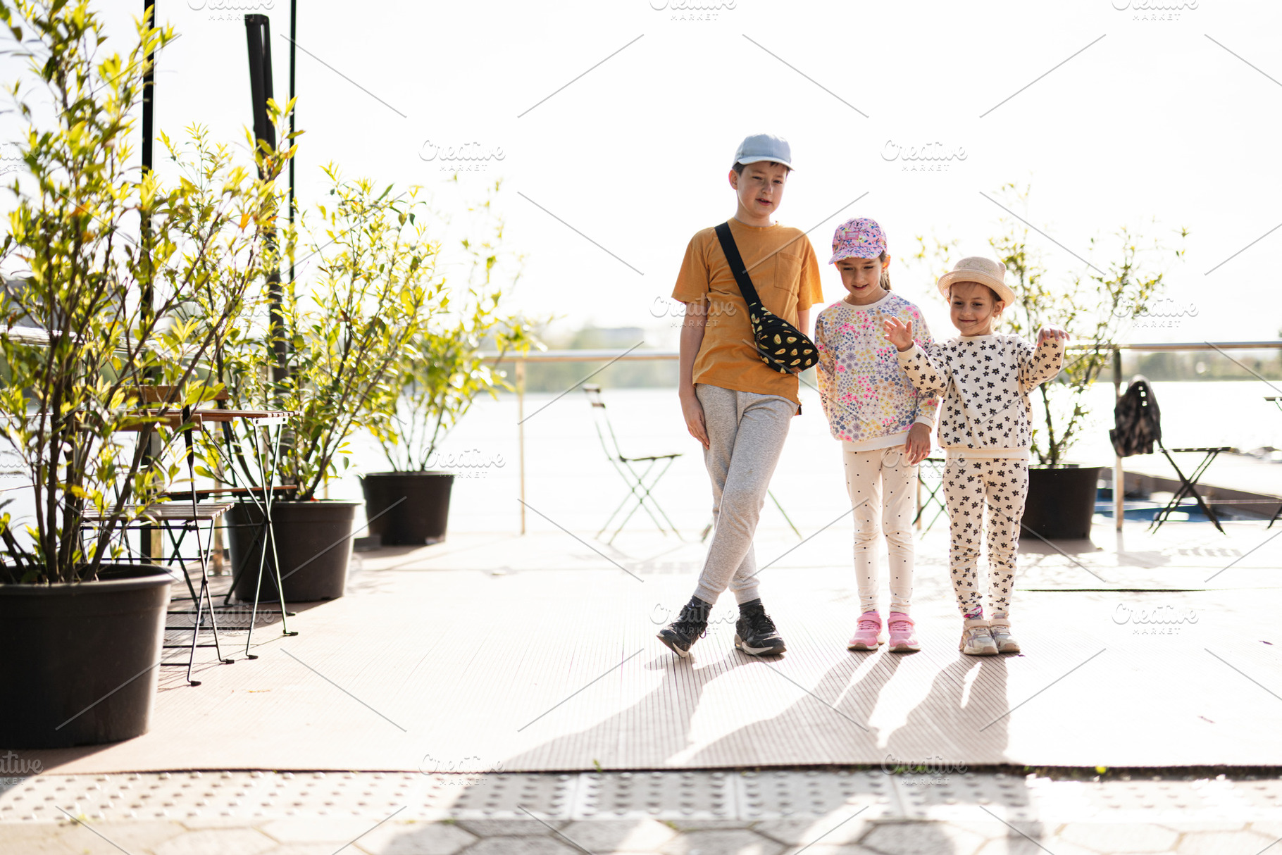 Three children outdoors enjoying a sunny day on a modern patio, a Person Photo by AS photostudio