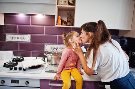 Mother with daughter cooking at kitchen, happy children's moment, a Person Photo by AS photostudio