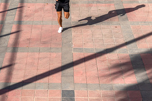 Male runner training on city pavement from above, a Person Photo by RF Images