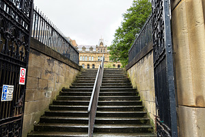 Stone steps and iron gate leading up to a historic sandstone bui