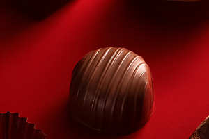 Chocolates and candies arranged on red, symbolizing love, desire, a Photo by Studio ANNA