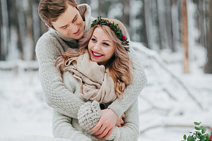 Happy newlyweds are hugging in the winter forest couple in love winter