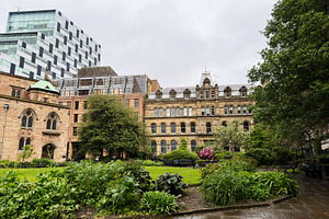 Historic sandstone buildings and a modern glass tower overlookin