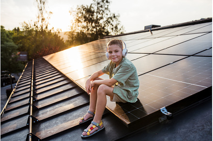 Cute boy sitting on roof with solar