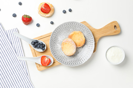Concept of tasty sweet food, cheese pancakes, top view, a Food & Drink Photo by AtlasStudio