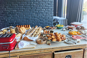Buffet table with bread, pastries, a Food & Drink Photo by sceptical cactus