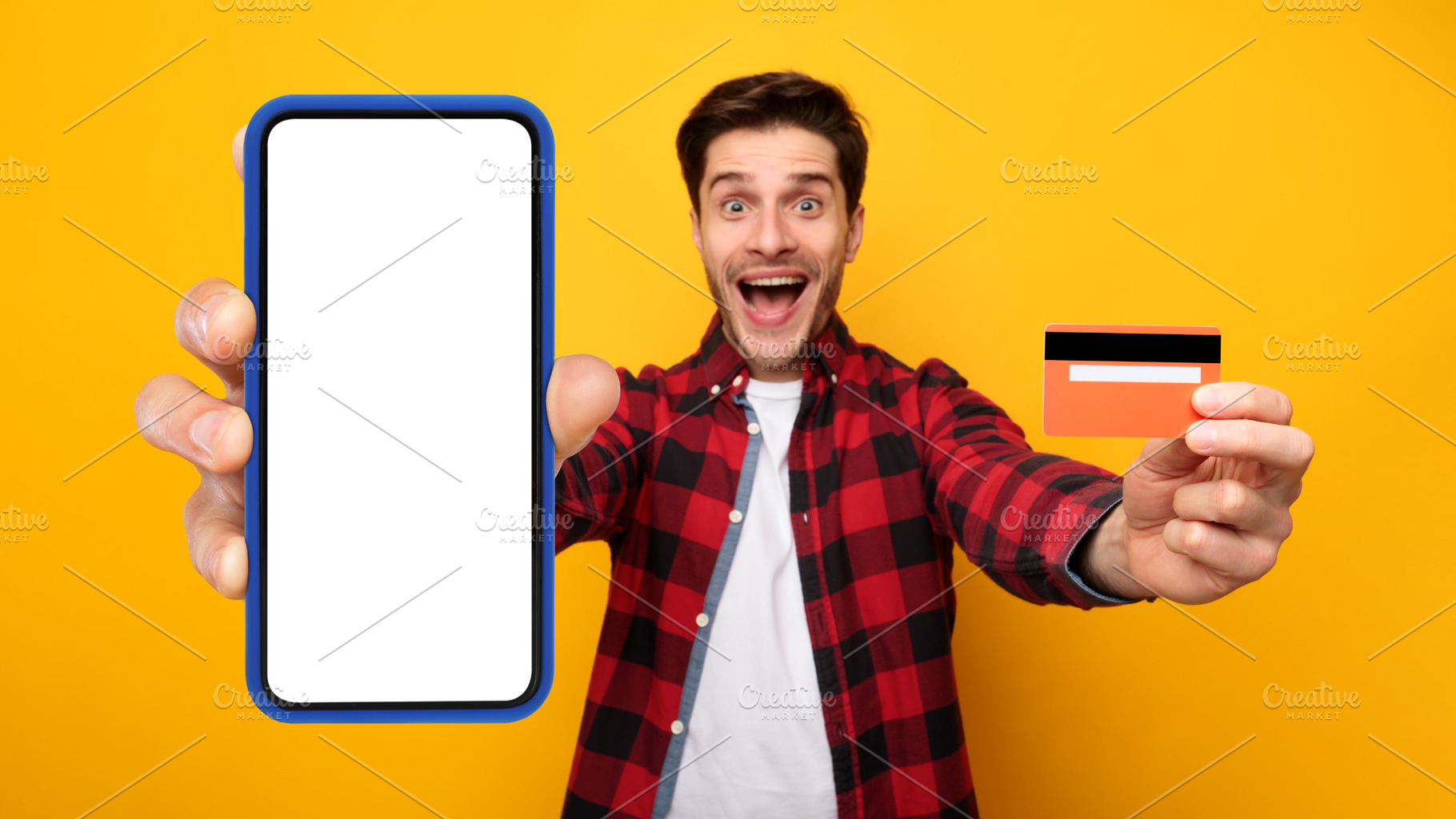 Excited mman showing blank cellphone screen and credit card, a Photo by Prostock-Studio