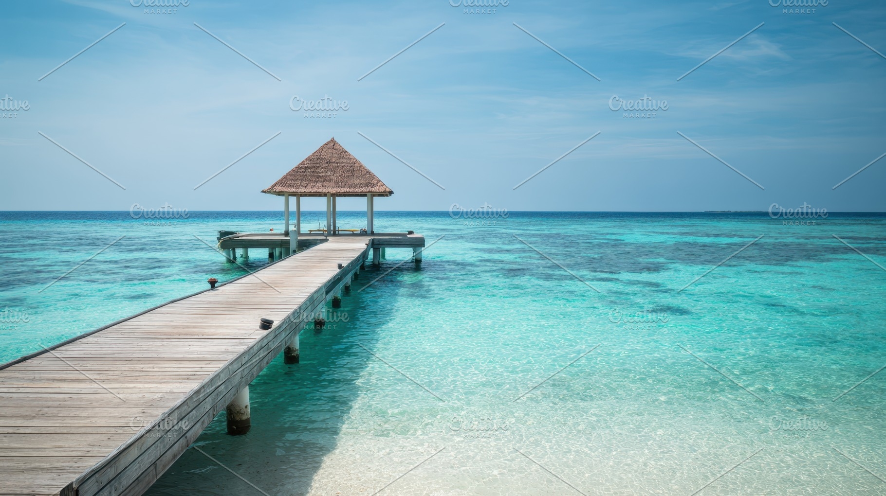 Wooden pier to gazebo over tropical water, a Nature Photo by AlyaAnd