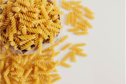 Spiral pasta in a paper bag on a, a Food & Drink Photo by olhovyi_photographer