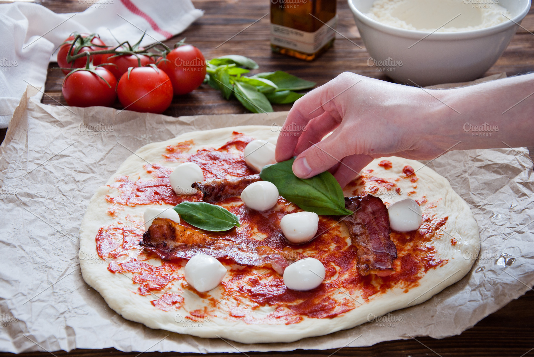 Cooking homemade pizza containing bacon, basil, and cheese, a Food & Drink Photo by letterberry