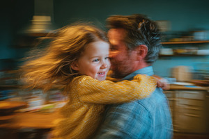 Happy child twirling in fathers arms, a Photo by Pixeness Studio