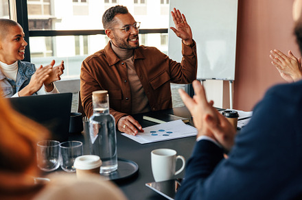 Businesspeople applauding their colleague in a boardroom, a Person Photo by Jacob Lund