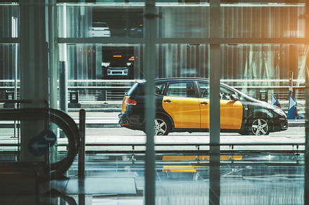 Cab near an airport terminal facade, a Business Photo by SkyNext