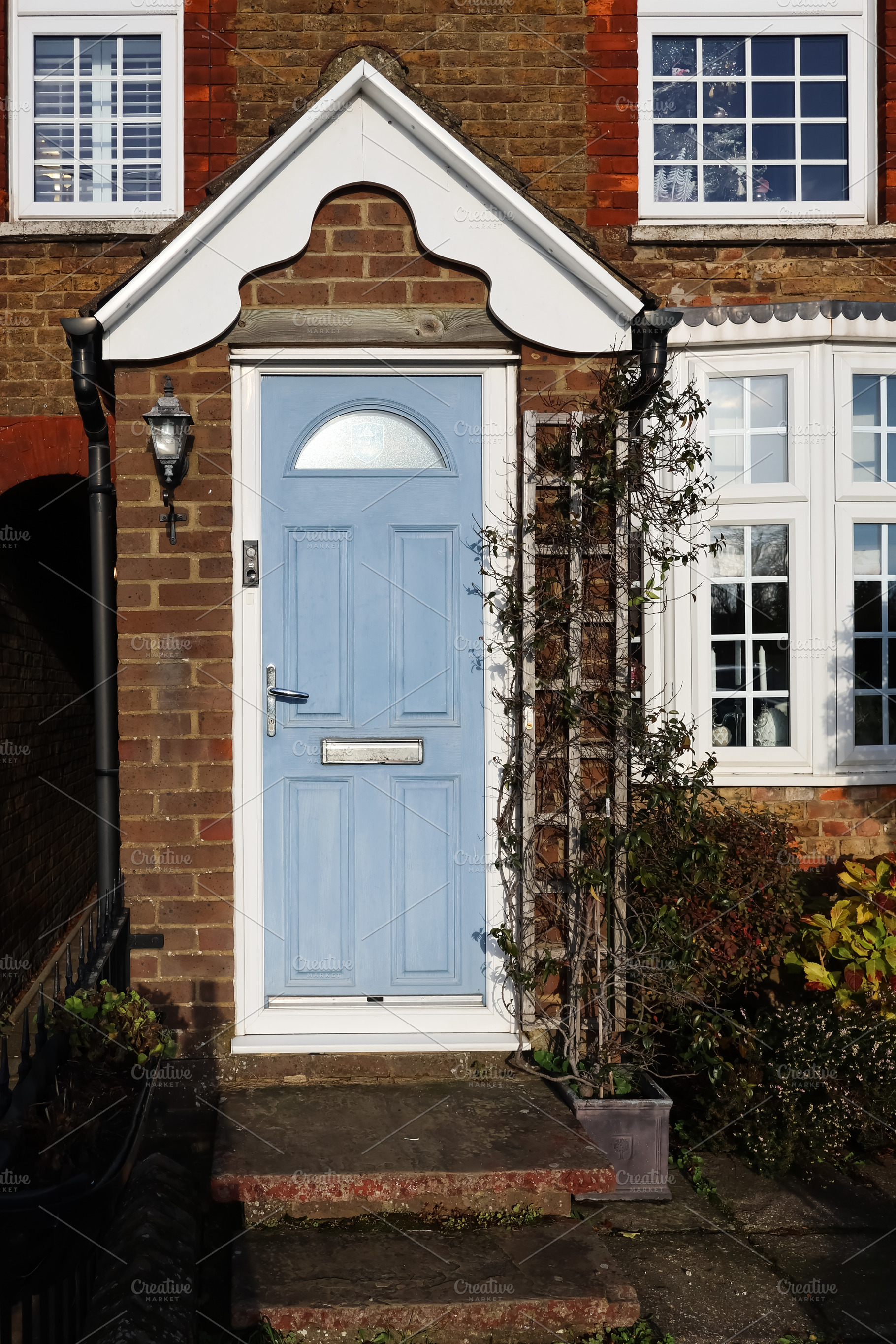 Residential facade featuring a light blue front door, white door, a Photo by Studio ANNA