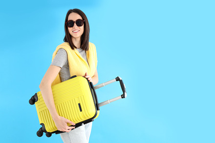 Attractive woman with travel bag on blue background, a Person Photo by AtlasStudio PRO